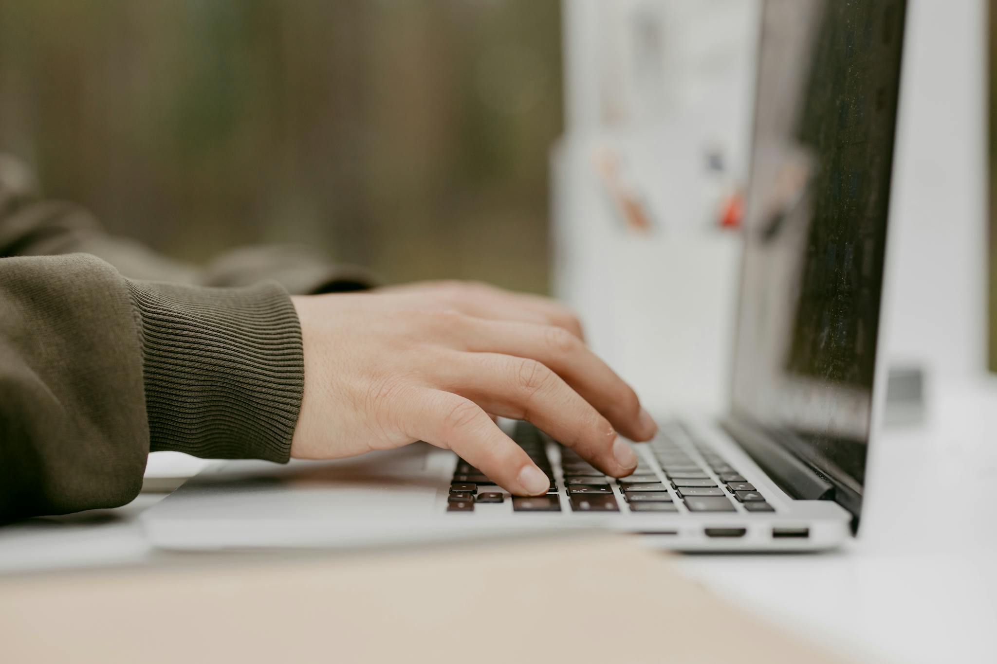Close-up of hands typing on a laptop keyboard, ideal for technology and lifestyle themes.